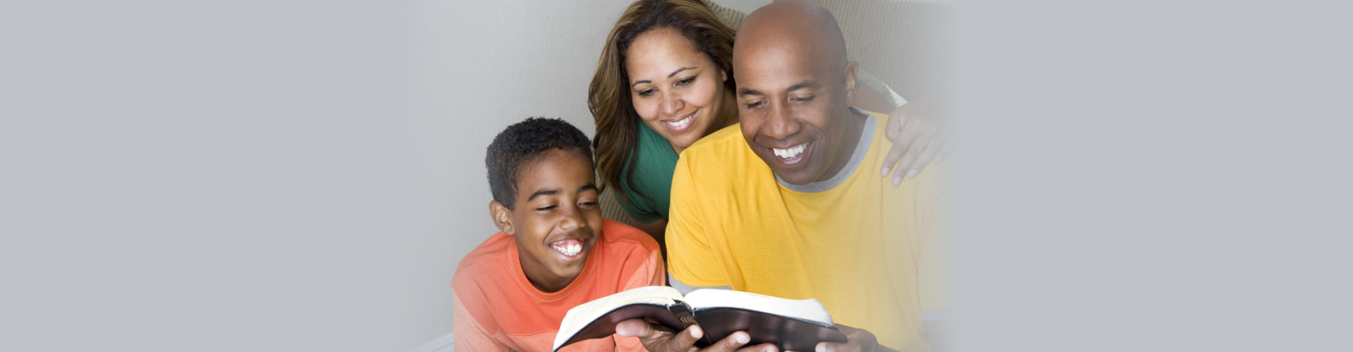 African American multicultural family reading The Bible